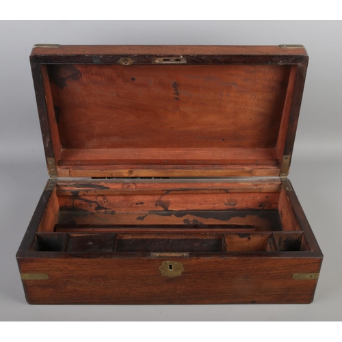 264 - A mahogany writing box with brass mounts, escutcheon and central floral plaque. The hinged top revea... 