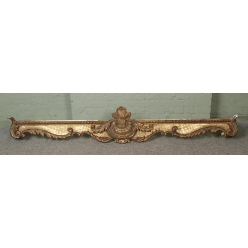 273 - A very large gilt wood and plaster pelmet, worked with central floral crest surrounded by carved flo... 