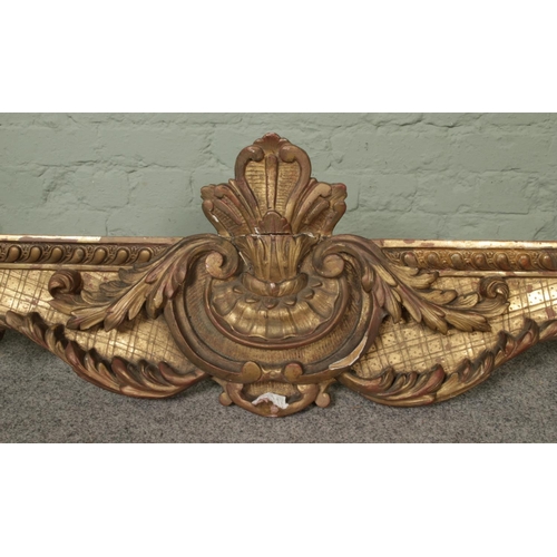 273 - A very large gilt wood and plaster pelmet, worked with central floral crest surrounded by carved flo... 