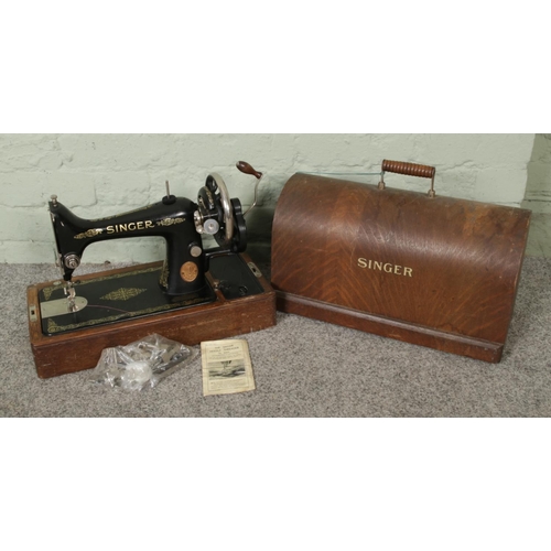 284 - A c1930 vintage Singer hand operated sewing machine, oak cased with key, together with various parts... 