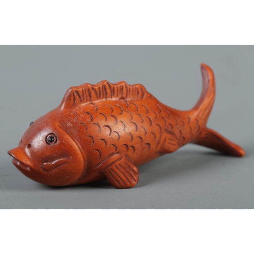 344 - A hand carved hardwood netsuke formed as a koi fish, signed to base.