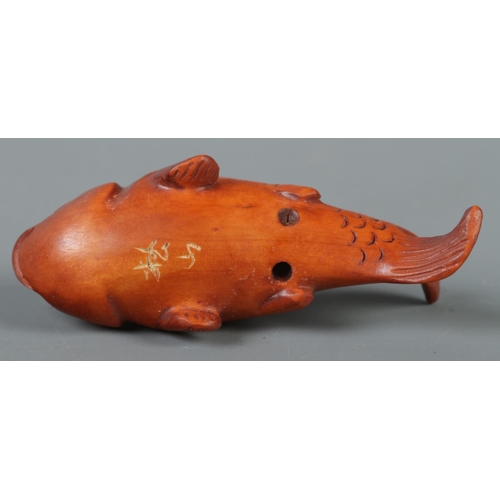 344 - A hand carved hardwood netsuke formed as a koi fish, signed to base.