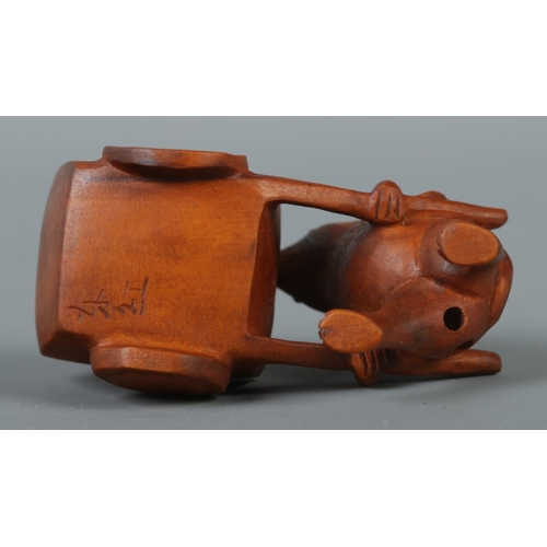 345 - A hand carved hardwood netsuke formed as a mouse pushing a cart, signed to base.