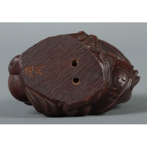 348 - A hand carved hardwood netsuke formed as a dragon, signed to base.