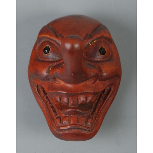 349 - A hand carved hardwood netsuke formed as a Tengu mask, signed to reverse.