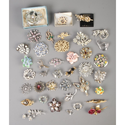 64 - A collection of over 35 assorted costume jewellery brooches of mainly floral examples.