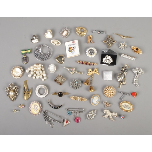 68 - A collection of assorted costume jewellery brooches and pin badges to include tigers eye, mother of ... 