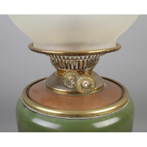 82 - A Victorian Duplex brass and ceramic oil lamp featuring painted bird amongst bamboo and frosted shad... 