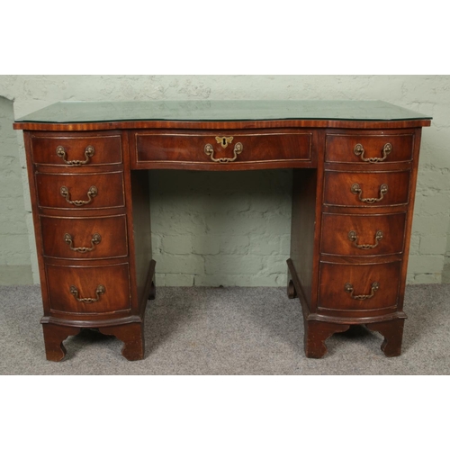 418 - A Georgian style mahogany serpentine desk with leather inset top.