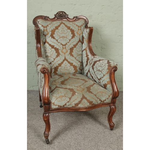 421 - A Victorian carved ladies arm chair on castors.