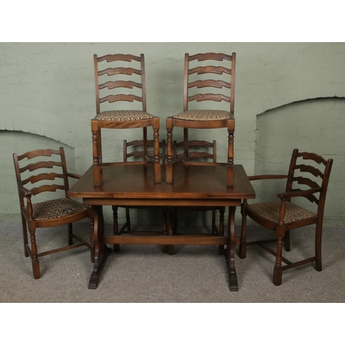 433 - A 20th century oak dining table with a set of four ladder back chairs