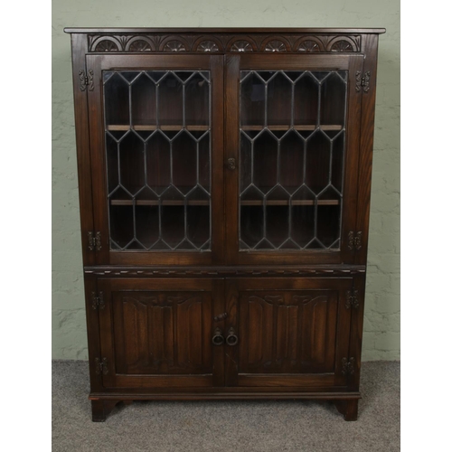 437 - A large oak display cabinet with linen fold carved doors below astragal glazed doors.

Hx135cm
Wx98c... 