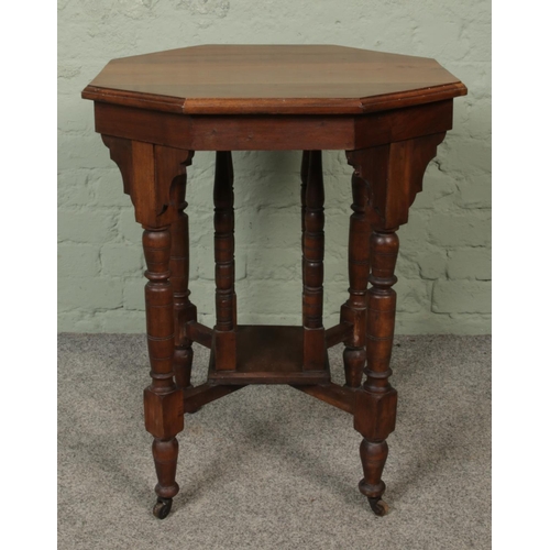 441 - A mahogany octagonal window table, with spindle supports. Raised on casters. Height: 74cm, Width: 61... 