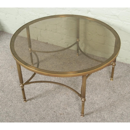 444 - A 1960's Maison Jansen style French coffee table, brass framed with smoked glass top, on reeded bras... 