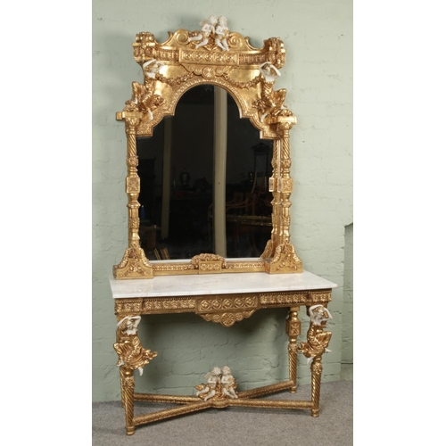 454 - A Rococo style gilt wood console table and matching mirror, with white marble top and figural decora... 