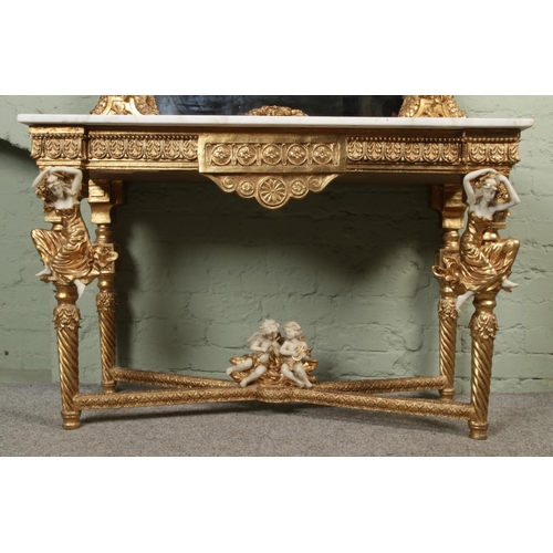 454 - A Rococo style gilt wood console table and matching mirror, with white marble top and figural decora... 