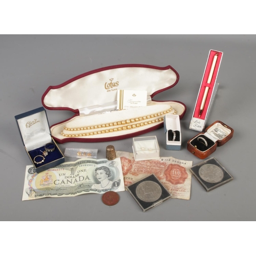 94 - A tin of jewellery and collectables. Includes Lotus simulated pearls, bank notes, Lady Scripto pen, ... 