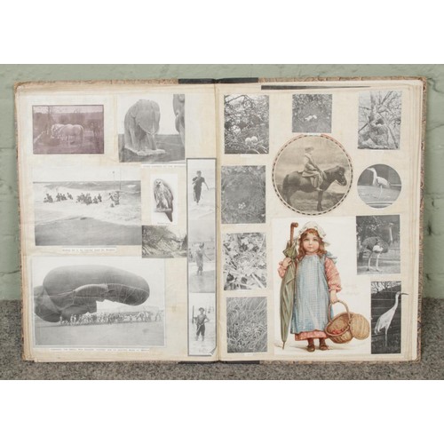 111 - An antique scrapbook filled with pictures, prints and newspaper clippings featuring animals, histori... 