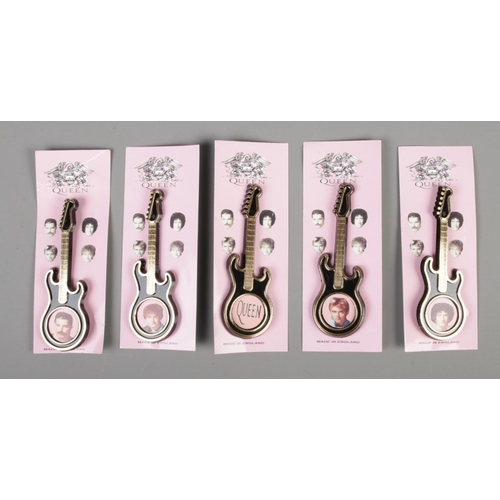 154 - A set of five Queen plastic guitar brooches, four featuring a portrait of a band member, the other t... 