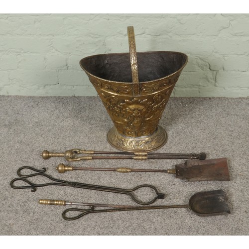 262 - A brass embossed coal scuttle with tongs and shovel etc