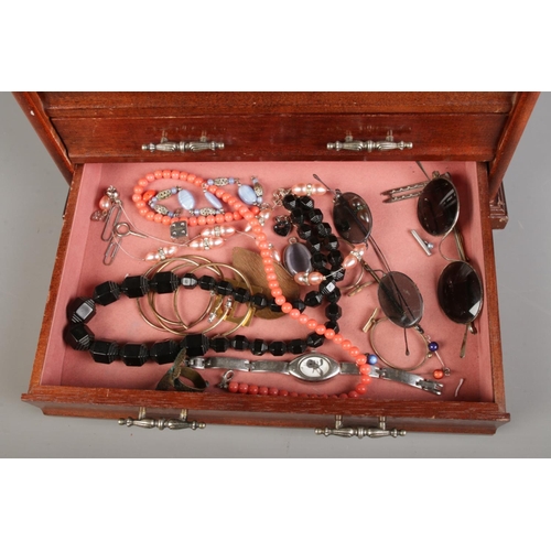 129 - An embroidered wooden jewellery box with two drawers, containing various vintage costume jewellery, ... 