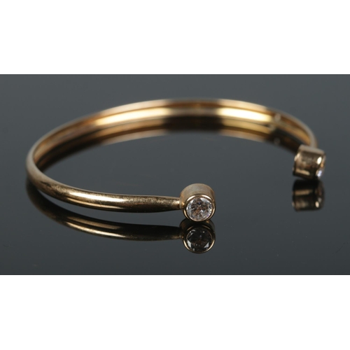 351 - A 9ct Gold child's bangle, set with a paste stone to both cuffs. Total weight: 1.9g