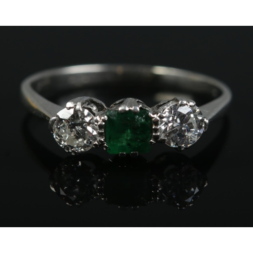 362 - An Art Deco platinum emerald and diamond ring. Each diamond approximately 0.25ct. Size M. 2.56g.