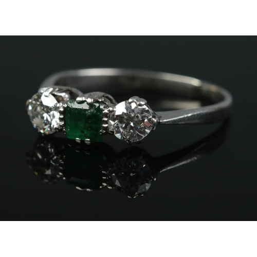 An Art Deco platinum emerald and diamond ring. Each diamond approximately 0.25ct. Size M. 2.56g.