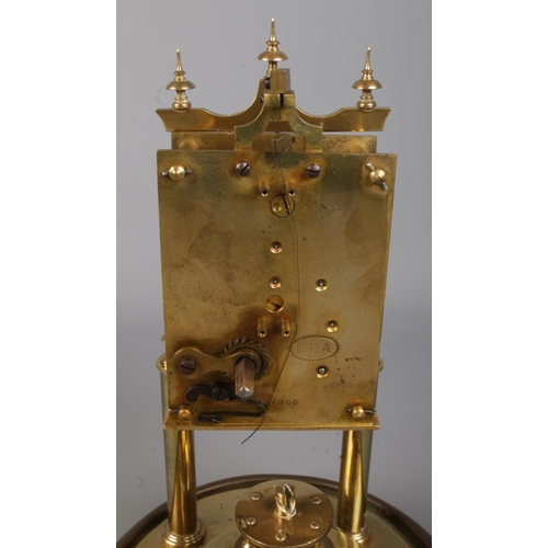 404 - A brass based anniversary mantle clock under glass dome. The movement stamped for BHA, with the face... 