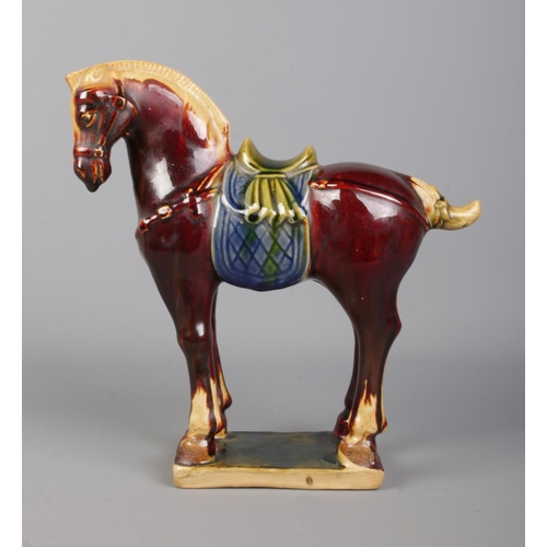 406 - A Chinese Tang Dynasty style glazed horse, raised on rectangular base. Bearing character marks to th... 