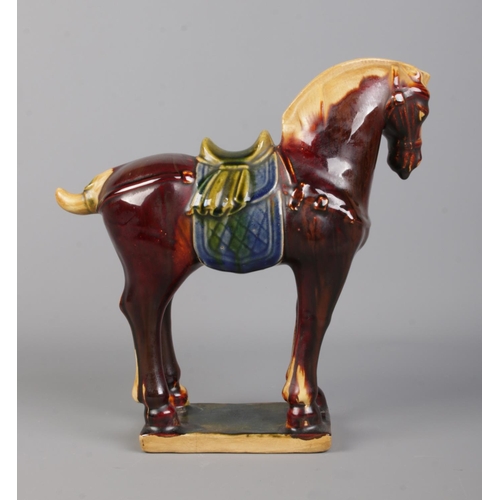 406 - A Chinese Tang Dynasty style glazed horse, raised on rectangular base. Bearing character marks to th... 