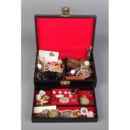 75 - A black jewellery box containing costume jewellery and watches, including necklaces, brooches, brace... 