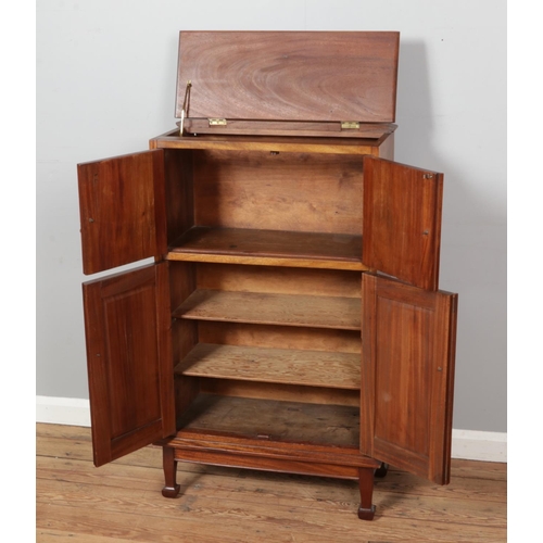 453 - A vintage bar cabinet featuring a flip-up lid on top, two small and two larger cabinet doors with wo... 