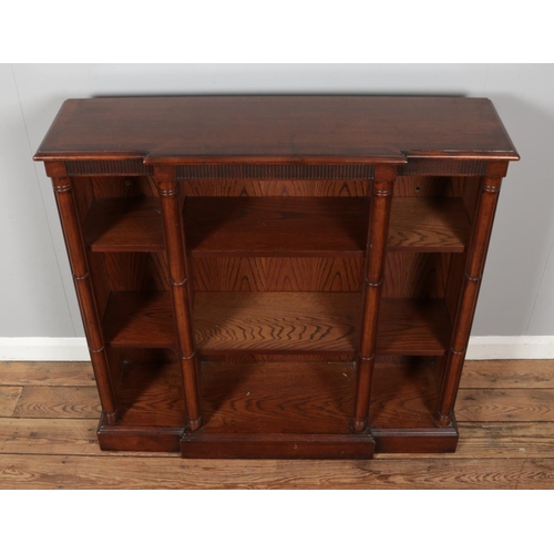 463 - A mahogany breakfront open bookcase/sideboard of small proportions. Featuring cylindrical column sup... 