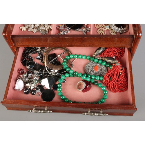 129 - An embroidered wooden jewellery box with two drawers, containing various vintage costume jewellery, ... 