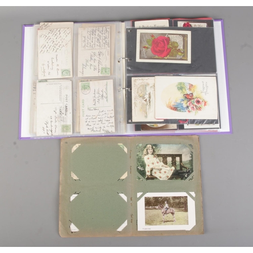 64 - Two albums containing early 20th century postcards and greetings cards to include international exam... 