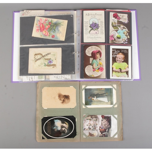 64 - Two albums containing early 20th century postcards and greetings cards to include international exam... 