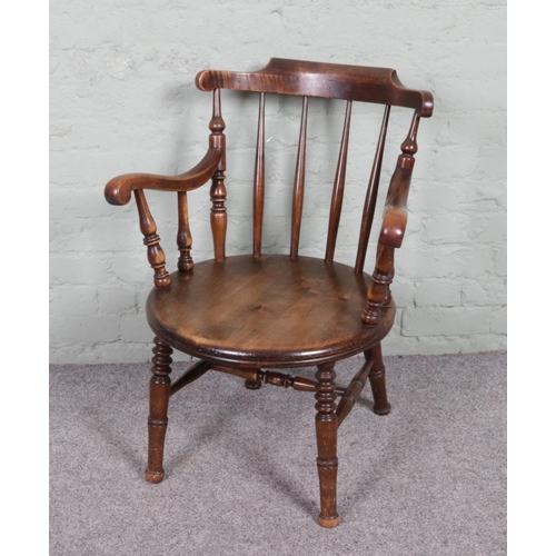 536 - A late 19th-century fireside elbow chair featuring shaped arms, a penny elm seat and four turned leg... 