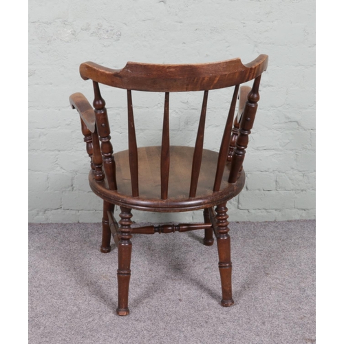 536 - A late 19th-century fireside elbow chair featuring shaped arms, a penny elm seat and four turned leg... 