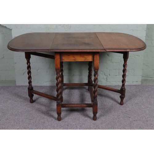 510 - An oak drop leaf gate leg table, with barley twist supports. Height: 74cm, Width (extended): 136cm, ... 