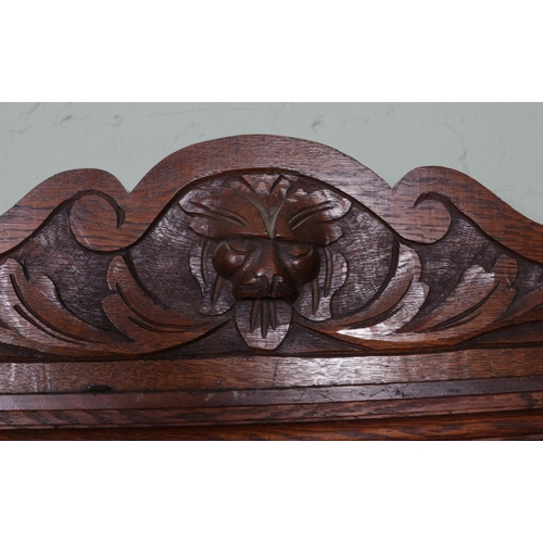 511 - An extensively carved oak hall stand. Featuring central bevel edged mirror and storage box situated ... 