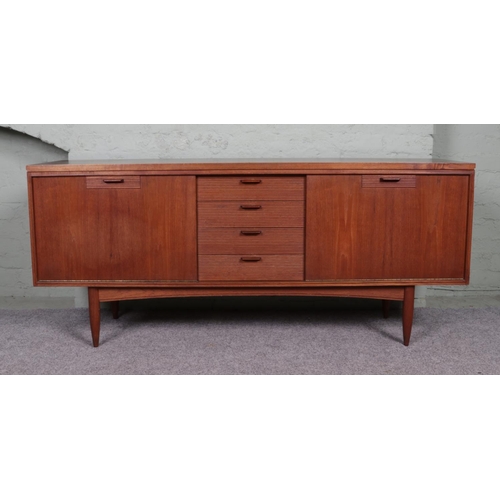 516 - A 1960's White and Newton of Portsmouth teak sideboard. Featuring a set of four drawers with waved f... 