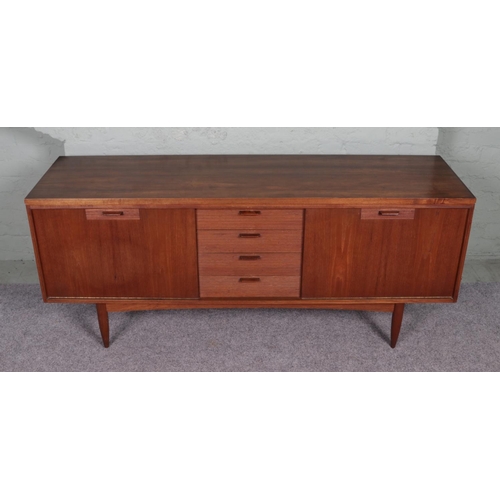 516 - A 1960's White and Newton of Portsmouth teak sideboard. Featuring a set of four drawers with waved f... 