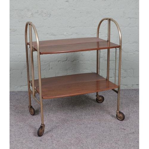 542 - A teak and tubular framed folding two-tier drinks trolley.