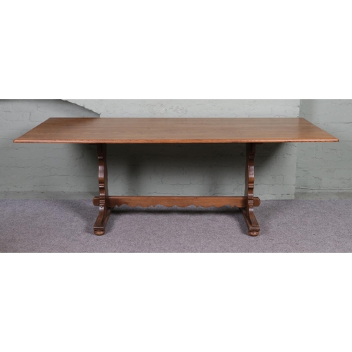 562 - A large Ercol style dining table, with central stretcher. Height: 71cm, Width: 213cm, Depth: 92cm.