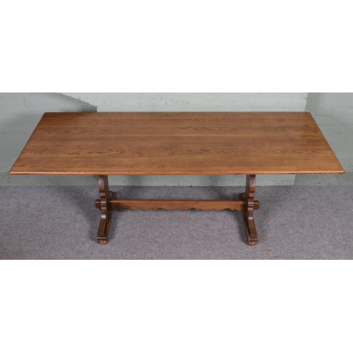 562 - A large Ercol style dining table, with central stretcher. Height: 71cm, Width: 213cm, Depth: 92cm.