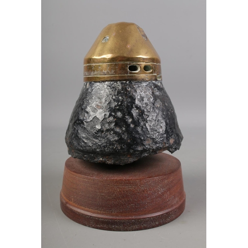 499 - A WWI Shrapnel shell fuse paperweight on wooden plinth