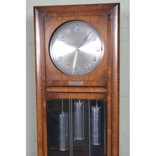 553 - An Art Deco style oak long cased clock with Arabic numeral markers and presentation plaque 'Presente... 