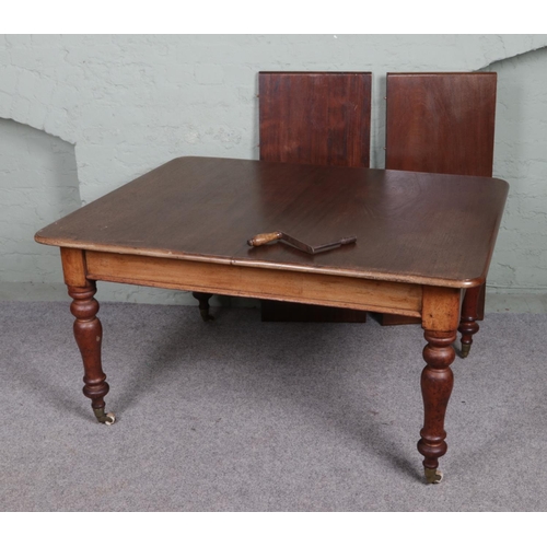 563 - A Victorian mahogany extending dining table with Cope & Collinson castors and two additional leaves.