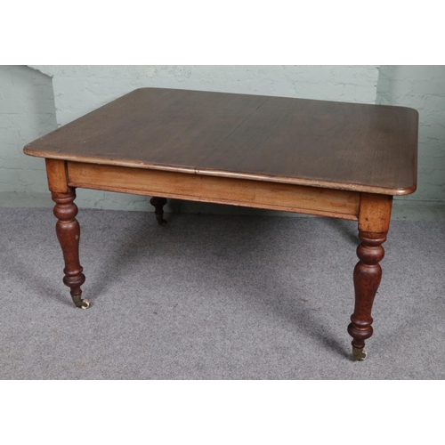 563 - A Victorian mahogany extending dining table with Cope & Collinson castors and two additional leaves.